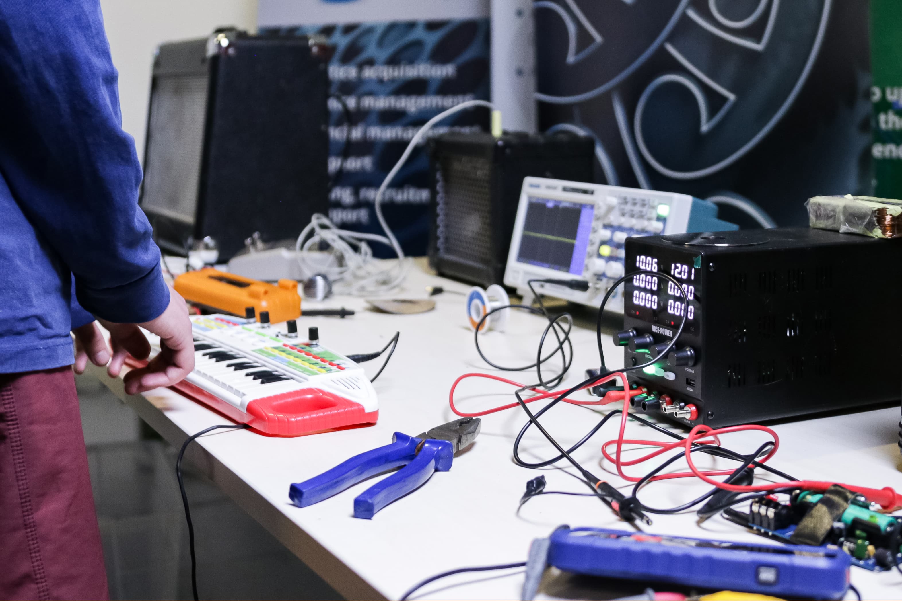 a toy keyboard, an oscilloscope, various repair tools